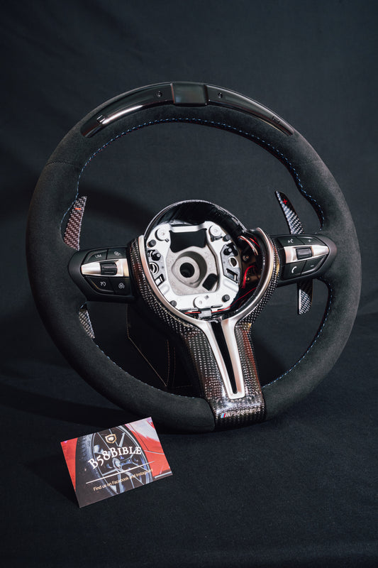 Front view of B58Bible full alcantara steering wheel with LED race lights, LCD display and carbon fibre paddle shifters